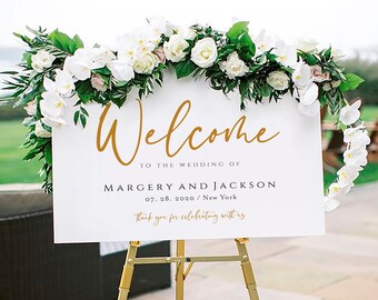 May include: White wedding welcome sign with gold calligraphy lettering on an easel. The sign reads "Welcome to the wedding of Margery and Jackson 07.28.2020 / New York thank you for celebrating with us"