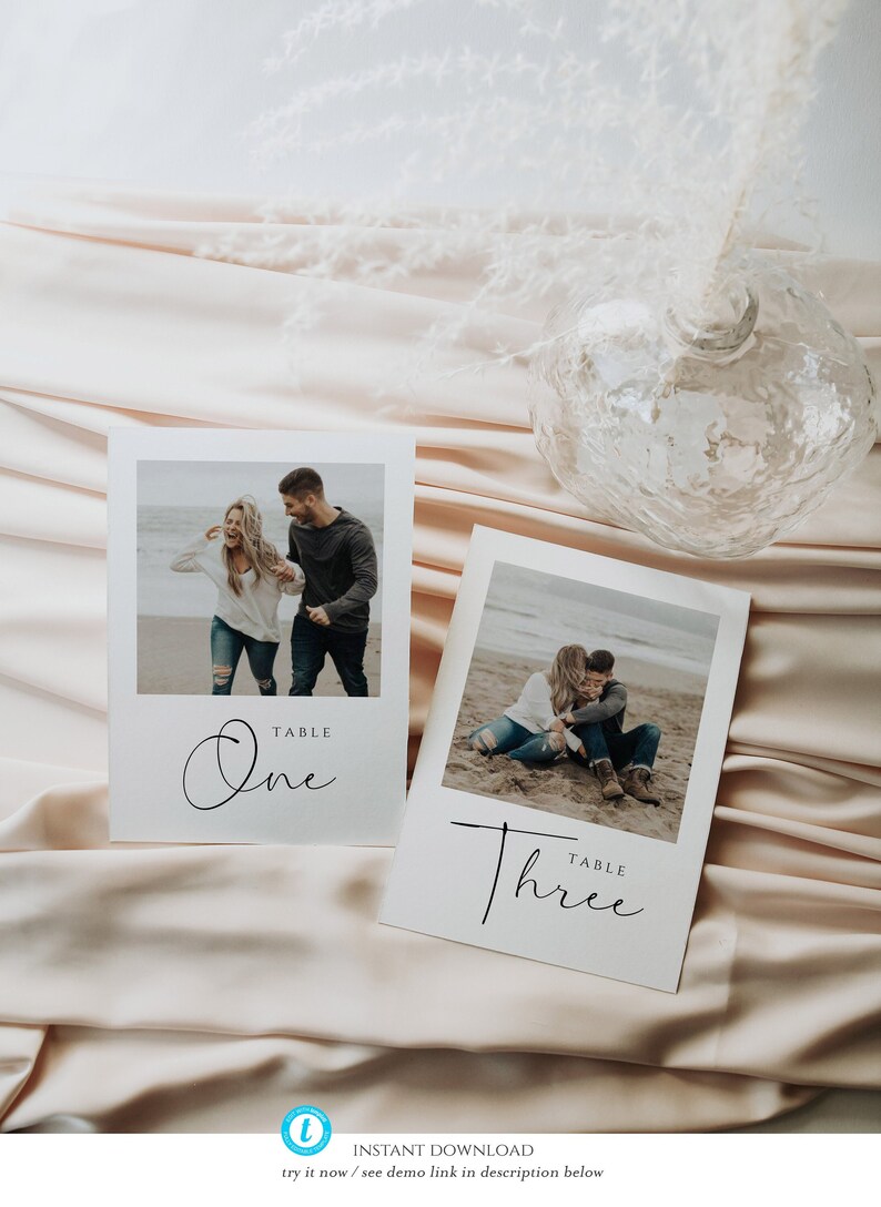 May include: Two white cards with black text and photos of a couple on a beach. The text on the cards reads "Table One" and "Table Three".