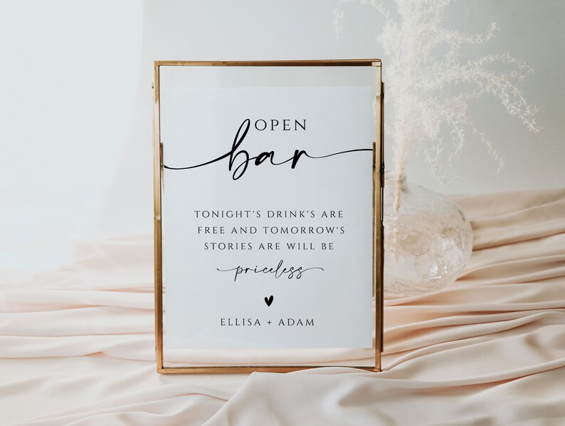 May include: A gold-framed sign with the text "OPEN bar" in a cursive font. The sign also includes the text "TONIGHT'S DRINK'S ARE FREE AND TOMORROW'S STORIES ARE WILL BE priceless" and "ELLISA + ADAM".