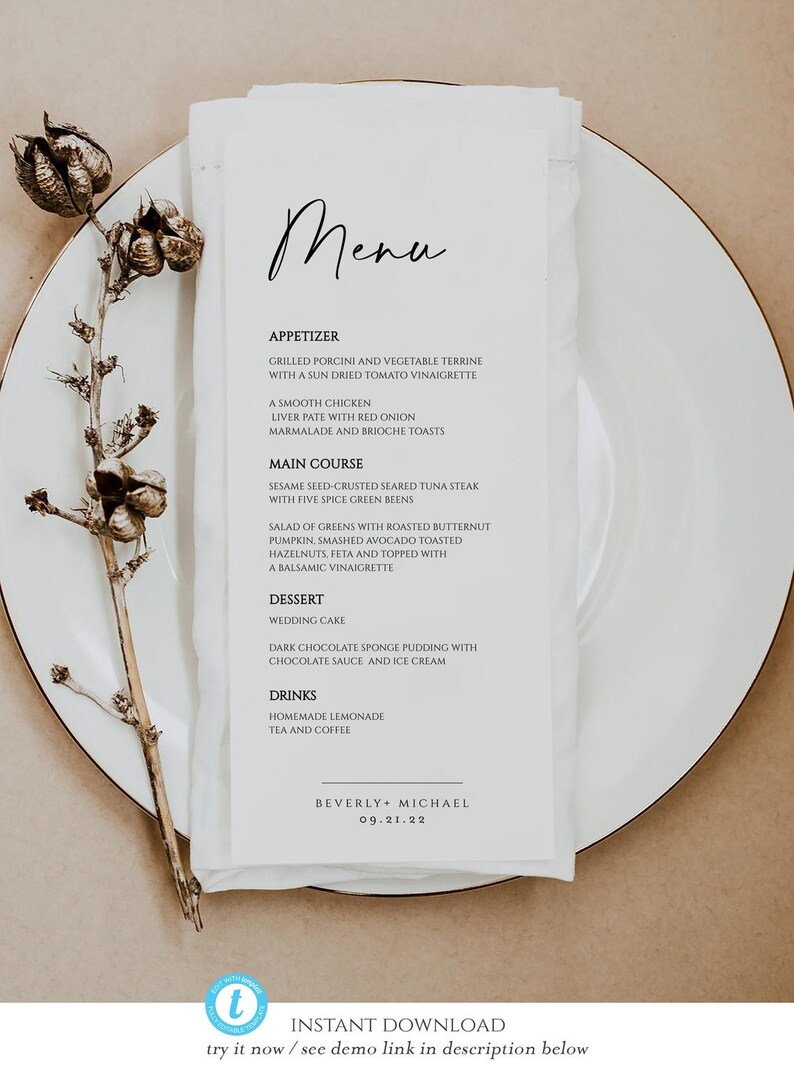K&ouml;nnte beinhalten: Eine Hochzeitskarte auf einer wei&szlig;en Serviette, pr&auml;sentiert auf einem wei&szlig;en Teller. Die Speisekarte zeigt den handgeschriebenen Titel "Menu" und eine Liste von Vorspeisen, Hauptgerichten, Dessert und Getr&auml;nken. Die Speisekarte ist mit einer getrockneten Pflanze verziert.