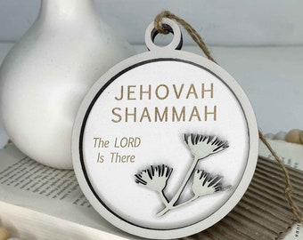 May include: White wooden ornament with the text "Jehovah Shammah The Lord Is There" and a stylized floral design.