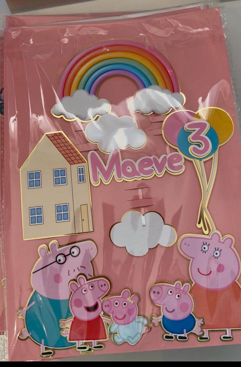 May include: A set of birthday cake toppers featuring a rainbow, clouds, a house, balloons, and Peppa Pig characters. The name "Maeve" and the number "3" are also included. The toppers are in a pink package.