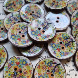 Peut inclure: Assortiment de boutons ronds en bois avec un motif floral et arboricole. Les boutons sont multicolores avec des nuances de jaune, bleu, rouge et vert. Les boutons ont deux trous chacun.