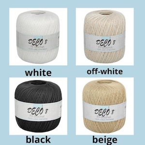 Op de afbeelding: Vier bollen Deco 8 Fil Crochet garen in wit, gebroken wit, zwart en beige. Elke bol heeft een etiket met de merknaam en productdetails. Het garen is 100% gemerceriseerd katoen.
