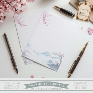 Puede incluir: Un juego de papelería con papel blanco con un diseño de paisaje en acuarela y detalles de flores de cerezo. Incluye dos bolígrafos y una etiqueta que dice "Created by PRO ART CREATION". También se ve el texto "Tranquility Awaits Printable Stationery".
