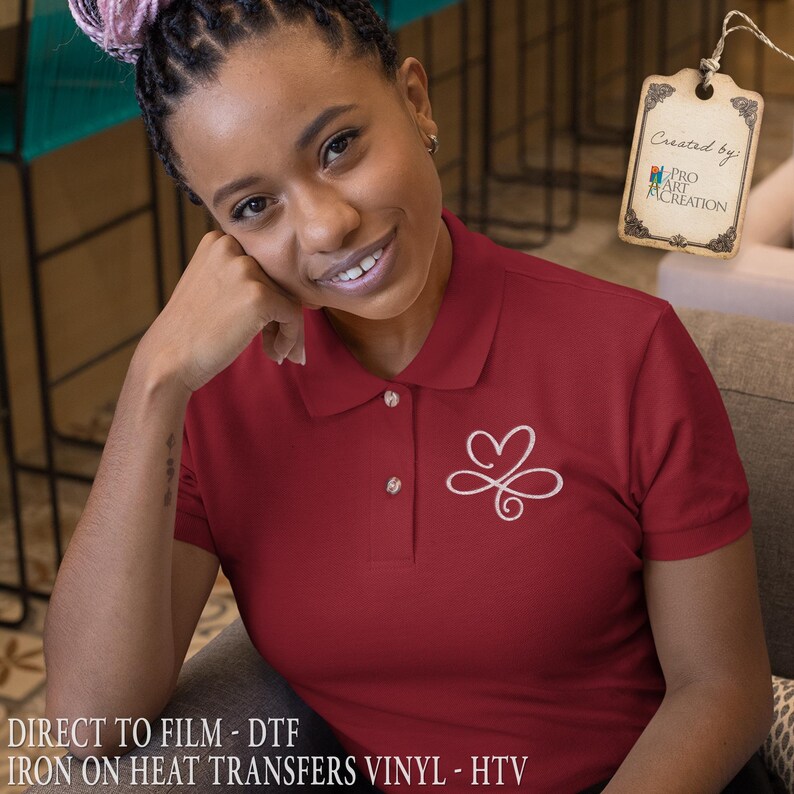 Puede incluir: Un polo granate con un dise&ntilde;o blanco en forma de coraz&oacute;n en el pecho izquierdo. La camisa tiene cuello y tres botones. El texto "DIRECT TO FILM - DTF IRON ON HEAT TRANSFERS VINYL - HTV" est&aacute; en la parte inferior de la imagen.