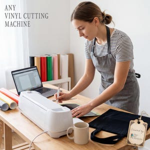 May include: A white vinyl cutting machine on a wooden table with a laptop, rolls of vinyl, and a coffee mug. The text "ANY VINYL CUTTING MACHINE" is at the top left. A person is using the machine.