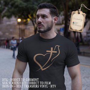 May include: Black t-shirt featuring a gold-colored graphic of a heart, cross, and dove. The shirt has short sleeves and is made of a soft material. The tag says "Created by: PRO ART CREATION".