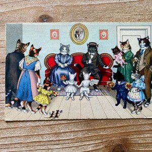 May include: A vintage postcard depicting a gathering of cats dressed in attire. The cats are assembled in a living room setting with a red sofa, a fireplace, and a framed picture on the wall. The cats are wearing a variety of clothing, including a dress, a suit, and a hat. The postcard is in good condition and has a vintage feel.