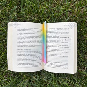 A gradient bookmark sitting inside of be love now book.