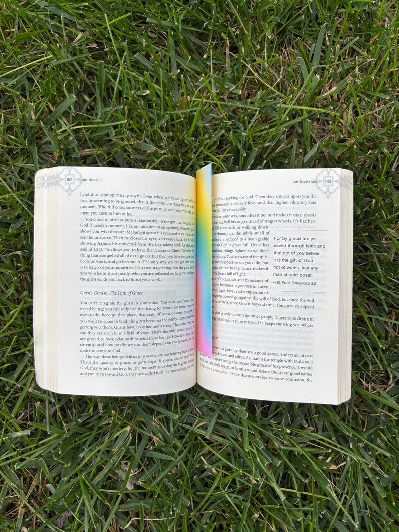A gradient bookmark sitting inside of be love now book.