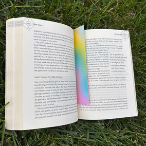 A gradient bookmark sitting inside of be love now book.