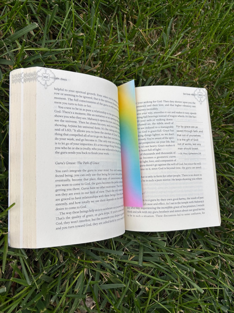 A gradient bookmark sitting inside of be love now book.