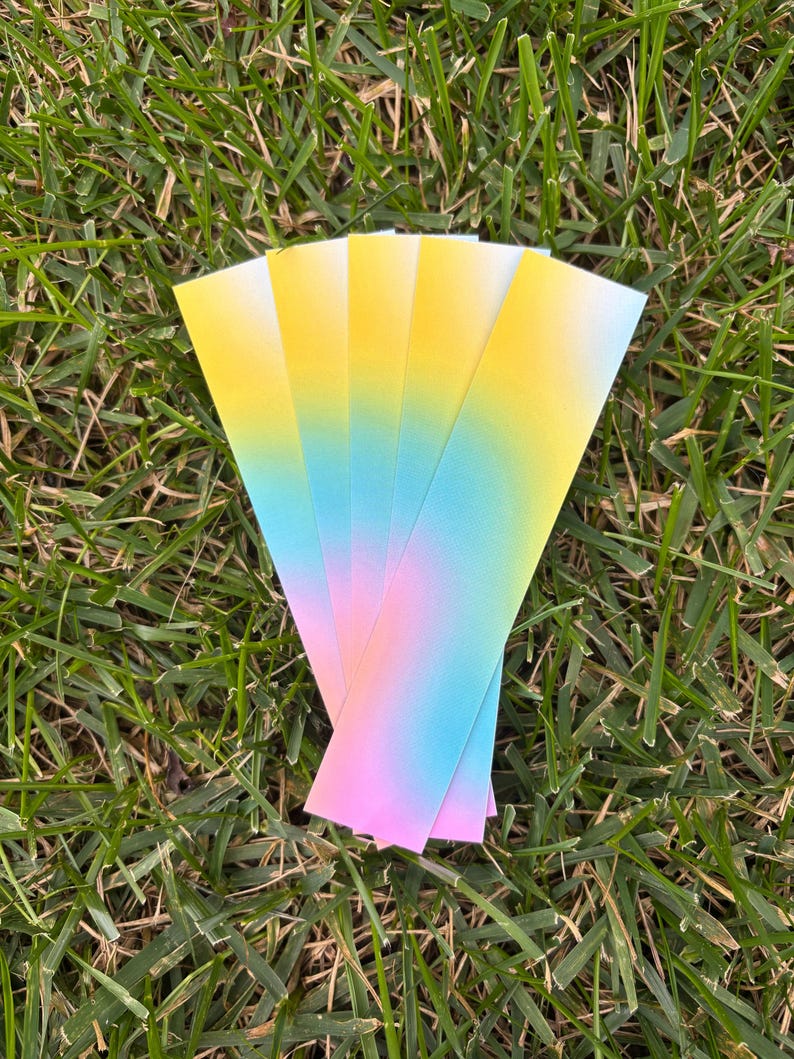 A handful of the gradient bookmarks sitting on some grass.