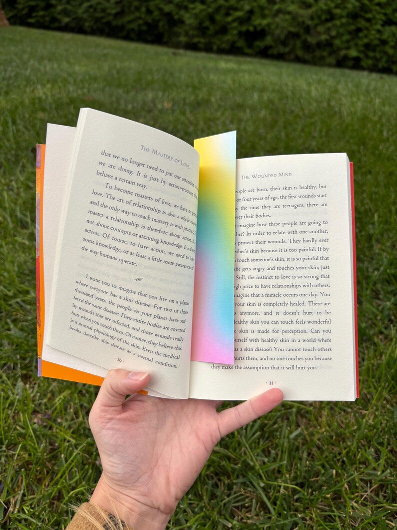 A gradient bookmark inside of a don miguel ruiz book.