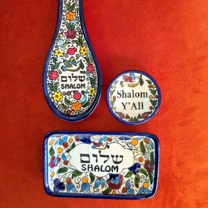 Könnte beinhalten: Drei Keramik-Servierplatten mit blauen und weißen Blumendesigns. Die Platten zeigen das hebräische Wort "Shalom" in einer weißen Wolke mit blauem Rand. Die kleinere Platte sagt "Shalom Y'all".