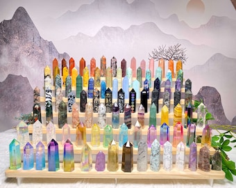 May include: A collection of colorful crystal points arranged on a wooden stand. The crystals are of various shapes and sizes, and they are all polished to a smooth finish. The stand is made of natural wood and has a simple design.