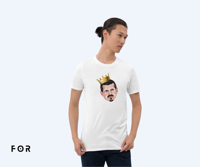 May include: White t-shirt with a cartoon illustration of a man wearing a gold crown. The man has a mustache and a beard.