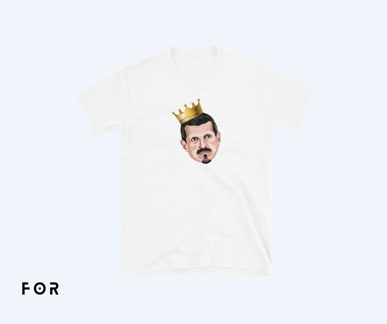 May include: White t-shirt with a cartoon illustration of a man wearing a gold crown.