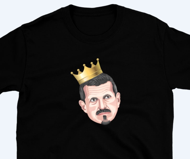 May include: A black t-shirt with a cartoon illustration of a man wearing a gold crown. The man has a mustache and goatee.