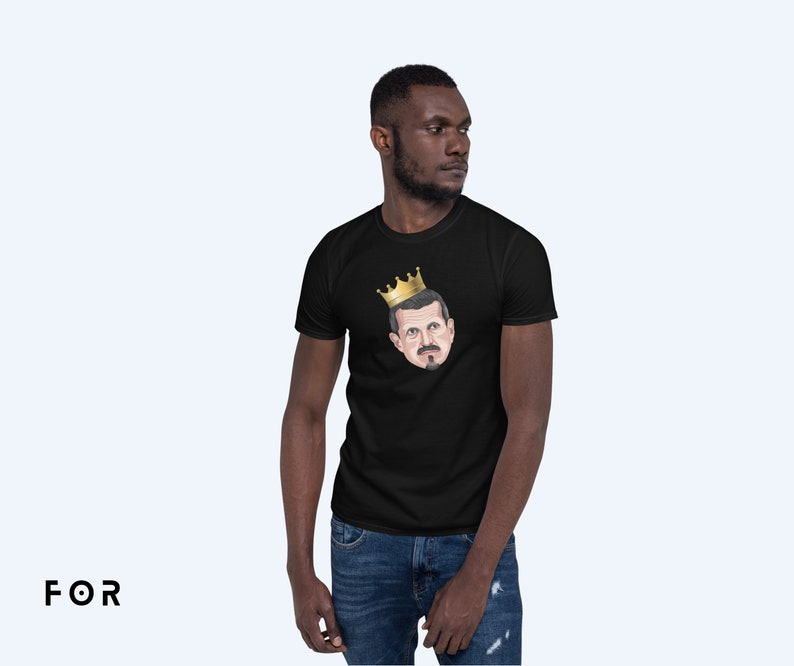 May include: A black t-shirt with a graphic of a man wearing a gold crown. The man has a mustache and beard.