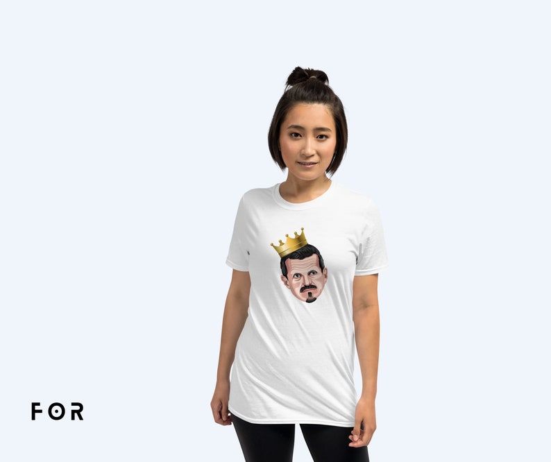 May include: A white t-shirt with a cartoon image of a man wearing a gold crown. The man has a mustache and a goatee.