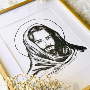 K&ouml;nnte beinhalten: Schwarz-wei&szlig;-Zeichnung von Jesus Christus mit Heiligenschein, der eine Robe tr&auml;gt und nach unten blickt. Die Zeichnung ist in einem goldenen Rahmen gerahmt.