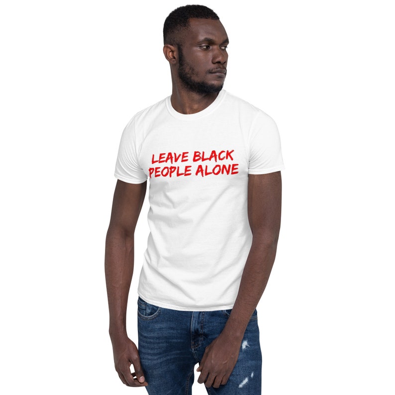 Puede incluir: Camiseta blanca con el texto "LEAVE BLACK PEOPLE ALONE" en letras rojas.