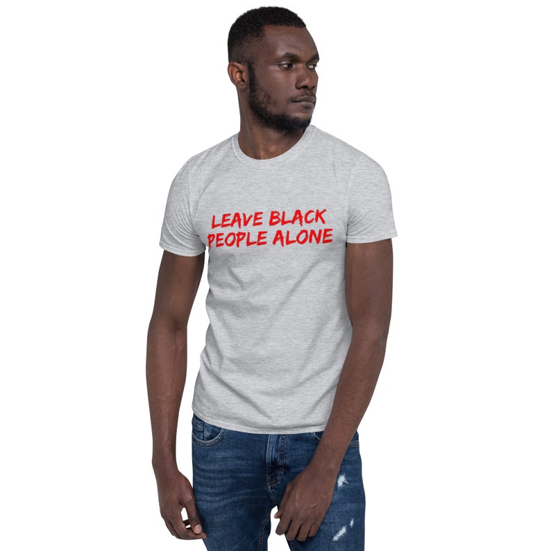 Puede incluir: Una camiseta gris jaspeada con el texto "LEAVE BLACK PEOPLE ALONE" en letras rojas.
