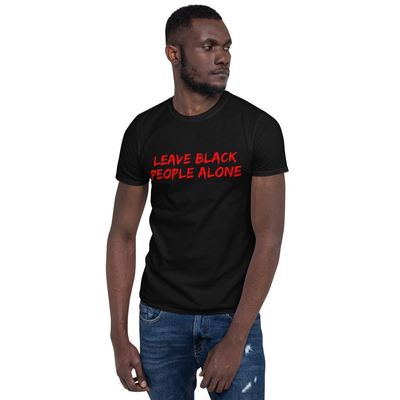 Puede incluir: Camiseta negra con el texto "LEAVE BLACK PEOPLE ALONE" en rojo.