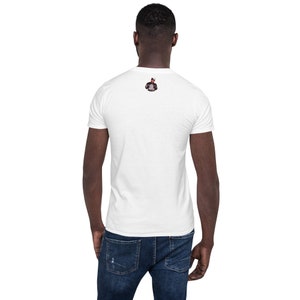 Puede incluir: Una camiseta blanca de manga corta con un peque&ntilde;o estampado gr&aacute;fico en la espalda.