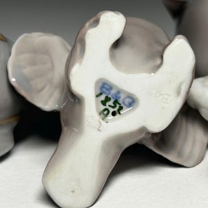 May include: Close-up of a collection of porcelain elephant figurines in various poses. The elephants are primarily gray with white accents and feature the B&G mark on the underside. The figurines are likely vintage or antique.