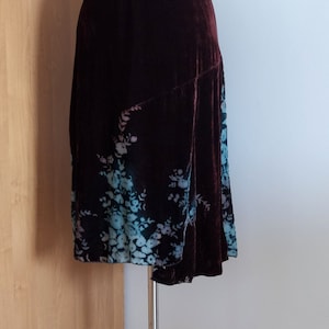 May include: A brown velvet skirt with a floral print in shades of blue and pink.