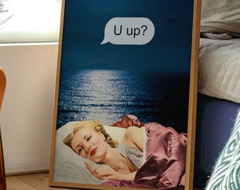 May include: A framed print of a woman sleeping in a bed with a blue sky and ocean in the background. A speech bubble above her says "U up?"