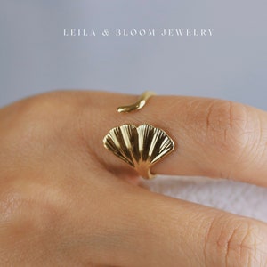 May include: Gold ring with a ginkgo leaf design. The ring is adjustable and can be worn on any finger.