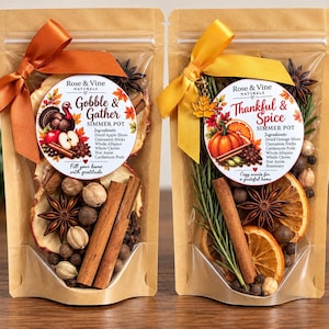 May include: Two kraft paper pouches containing simmer pot ingredients. The left pouch features a turkey graphic and 'Gobble & Gather' text, while the right pouch features a pumpkin graphic and 'Thankful & Spice' text, both tied with colored ribbons.