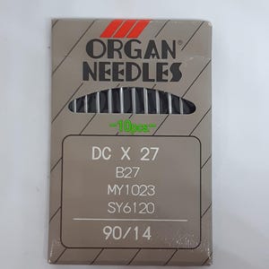May include: A package of Organ Needles sewing machine needles. The package is gray with red and black text. The text on the package includes "ORGAN NEEDLES", "DC X 27", "B27", "MY1023", "SY6120", and "90/14". The package contains 10 needles.