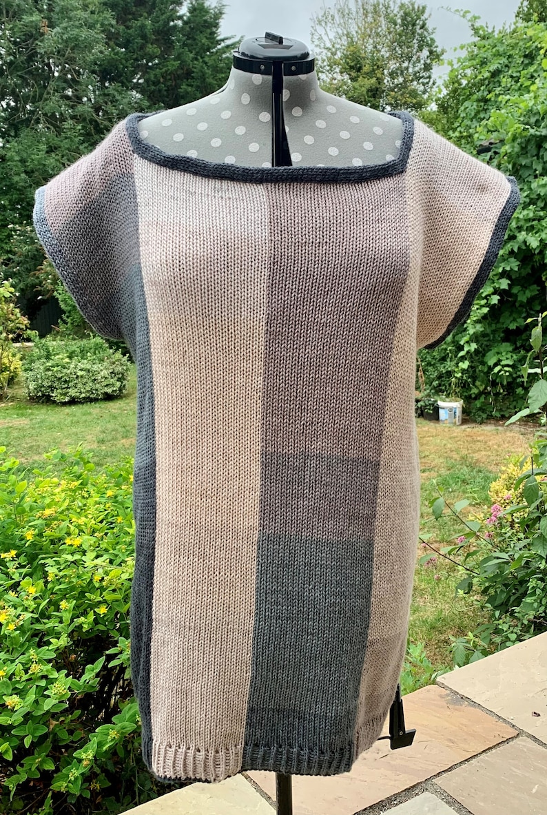 May include: A knitted top with a striped pattern in shades of gray, pink, and beige. The top has a scoop neck and short sleeves.