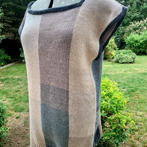 May include: A striped knit top with a square neckline and short sleeves. The top is made of a soft, textured yarn in shades of brown, gray, and beige.