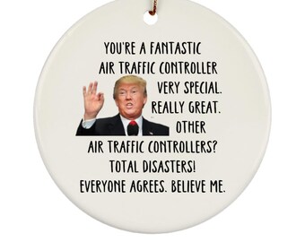 May include: White ceramic ornament with a black and white image of Donald Trump and the text "You're a fantastic air traffic controller. Very special. Really great. Other air traffic controllers? Total disasters! Everyone agrees. Believe me."