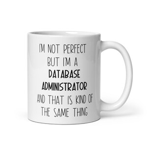 Könnte beinhalten: Eine weiße Keramik-Kaffeetasse mit schwarzem Text, der lautet: "Ich bin nicht perfekt, aber ich bin ein Datenbankadministrator, und das ist irgendwie dasselbe."