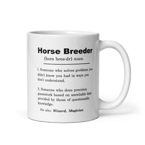 Peut inclure: Mug en céramique blanche avec l'inscription "Horse Breeder" et une définition. La définition comprend deux points décrivant le rôle d'un éleveur de chevaux, avec "See also: Wizard, Magician".