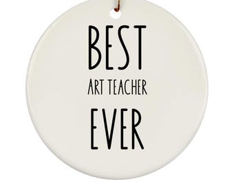 May include: A white, round ceramic ornament with the text "BEST ART TEACHER EVER" in black. The ornament has a gold string for hanging. A thoughtful gift for art teachers.