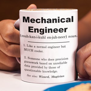 May include: White ceramic mug with a black design that reads "Mechanical Engineer (muh-kan-i-kuhl en-juh-neer) noun. 1. Like a normal engineer but MUCH cooler. 2. Someone who does precision guesswork based on unreliable data provided by those of questionable knowledge. See also: Wizard, Magician"