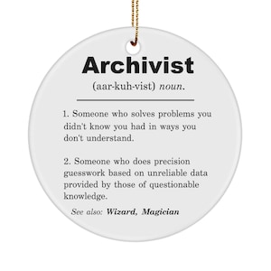 May include: White round ornament with black text defining the word "Archivist" as someone who solves problems in ways you don't understand. The text also says "See also: Wizard, Magician".