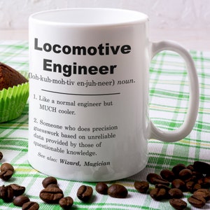 May include: White ceramic coffee mug with a black and white design that reads "Locomotive Engineer (loh-kuh-moh-tiv en-juh-neer) noun. 1. Like a normal engineer but MUCH cooler. 2. Someone who does precision guesswork based on unreliable data provided by those of questionable knowledge. See also: Wizard, Magician"