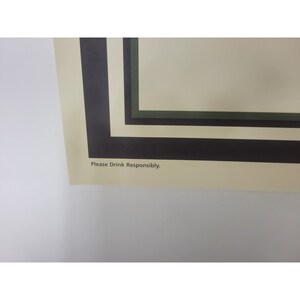 May include: A close-up of a poster with a black, white, and green border. The text "Please Drink Responsibly" is printed at the bottom of the poster.