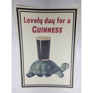 May include: A vintage poster advertising Guinness beer. The poster features a cartoon turtle carrying a glass of Guinness on its back. The text on the poster reads "Lovely day for a Guinness".