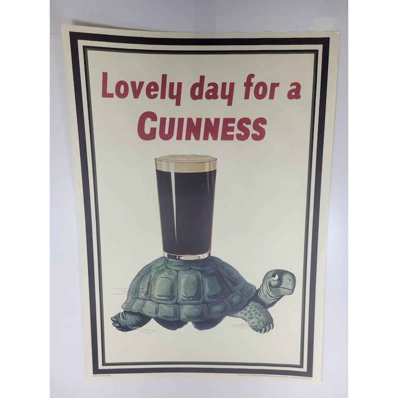 May include: A vintage poster advertising Guinness beer. The poster features a cartoon turtle carrying a glass of Guinness on its back. The text on the poster reads "Lovely day for a Guinness".
