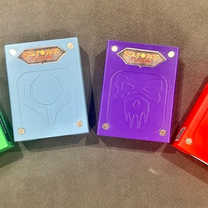 May include: Four different colored boxes with the text "Solforce Fusion" on the top. The boxes are green, blue, purple, and red. Each box has a different design on the front.